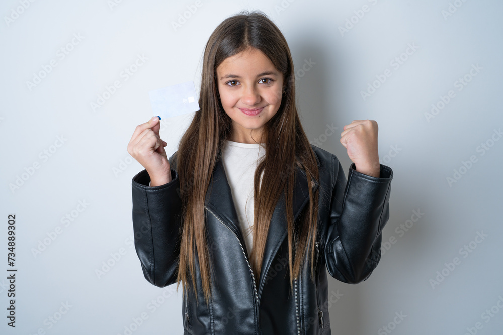 Photo of lucky impressed Young beautiful teen girl wearing biker jacket arm fist holding credit card. Celebrated Photo of lucky impressed Young beautiful teen girl wearing biker jacket arm fist holding credit card. Celebrated