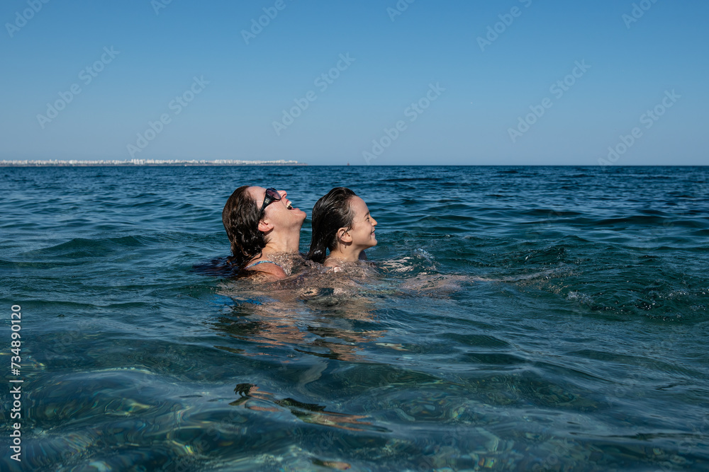 Mother and son having fun swimming in the sea. Happy family.