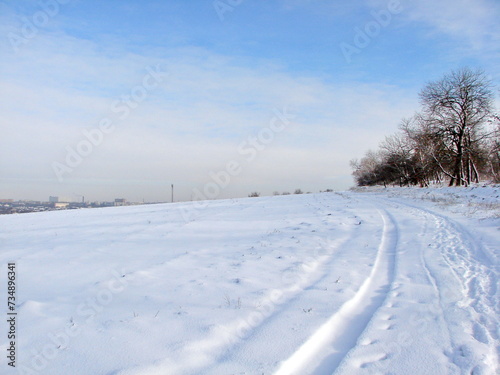 An amazing natural picture of the combination of the bright white color of the snowy steppe and the sunny white-blue sky in the frosty winter.