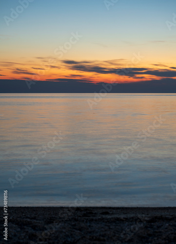 Tranquil scene of beautiful sea at sunset. Orange and yellow sunset on the sea. Aerial panoramic view of sunset over sea. Sithonia  Greece  Halkidiki. Paradisos Beach in Neos Marmaras.