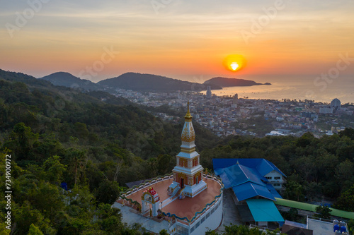 aerial view scenery sunset above pagoda of Doi Thepnimit temple on the highest of Patong mountain..The lights twinkle at twilight background..Scene of Colorful romantic sky sunset, beautiful pagoda.