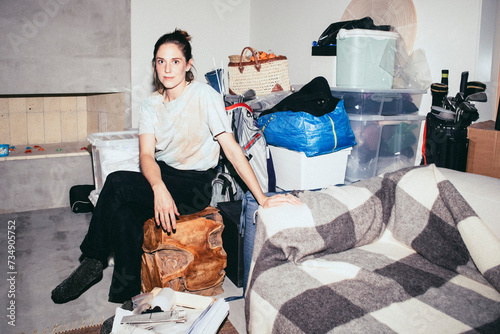 Portrait of woman sitting on wooden seat near boxes during relocation of house photo