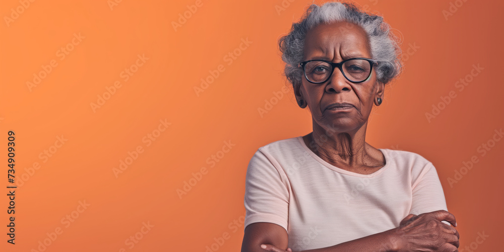 Grumpy senior black woman looking at camera with resentment and disapproval, on solid background with copy space. Grumpy senior black woman looking at camera with resentment and disapproval, on solid background with copy space.