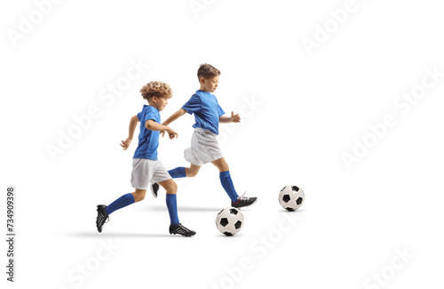 Full length profile shot of boys running with footballs