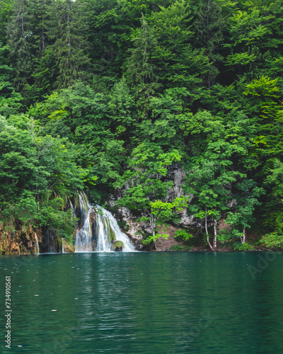 Beautiful waterfall surrounded by lush greenery in Plitvice Lakes National Park. Croatia