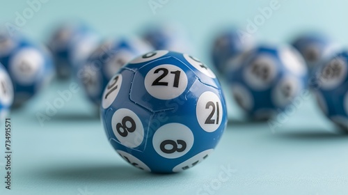 Close up of blue lottery balls with focus on lucky number 21, on a pastel solid color background