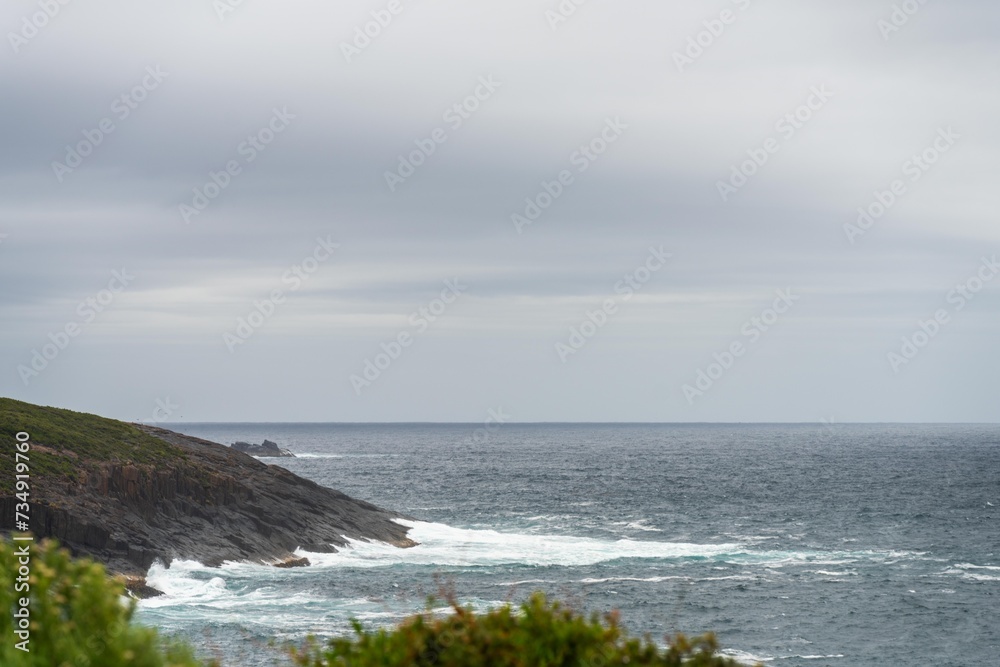 waves breaking on rocks in on the coast by the sea in tasmania australia in summer