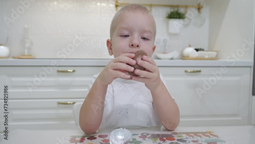 child little boy opening chocolate egg with surprise photo