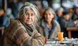 Positive elderly homeless woman , a homeless cafe. Urban poverty and hunger concept. Street lifestyle and survival.