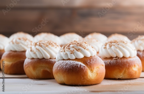 a bunch of easter buns with frosting on a wooden table, white and beige
