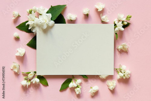 Blank greeting card, invitation and envelope mockup. Minimal floral frame made of jasmine flower. Flat lay, top view. Happy mother's day, women's day or birthday, wedding composition. © Olena Svechkova