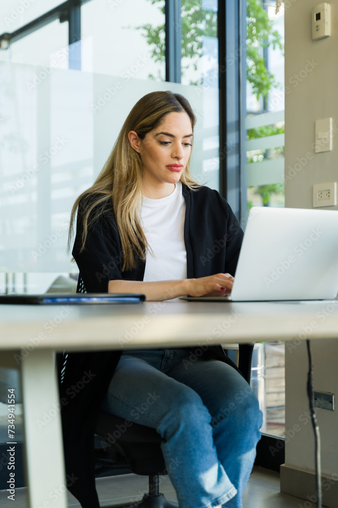 Portrait of a cute Caucasian office worker using a laptop computer in an office Portrait of a cute Caucasian office worker using a laptop computer in an office