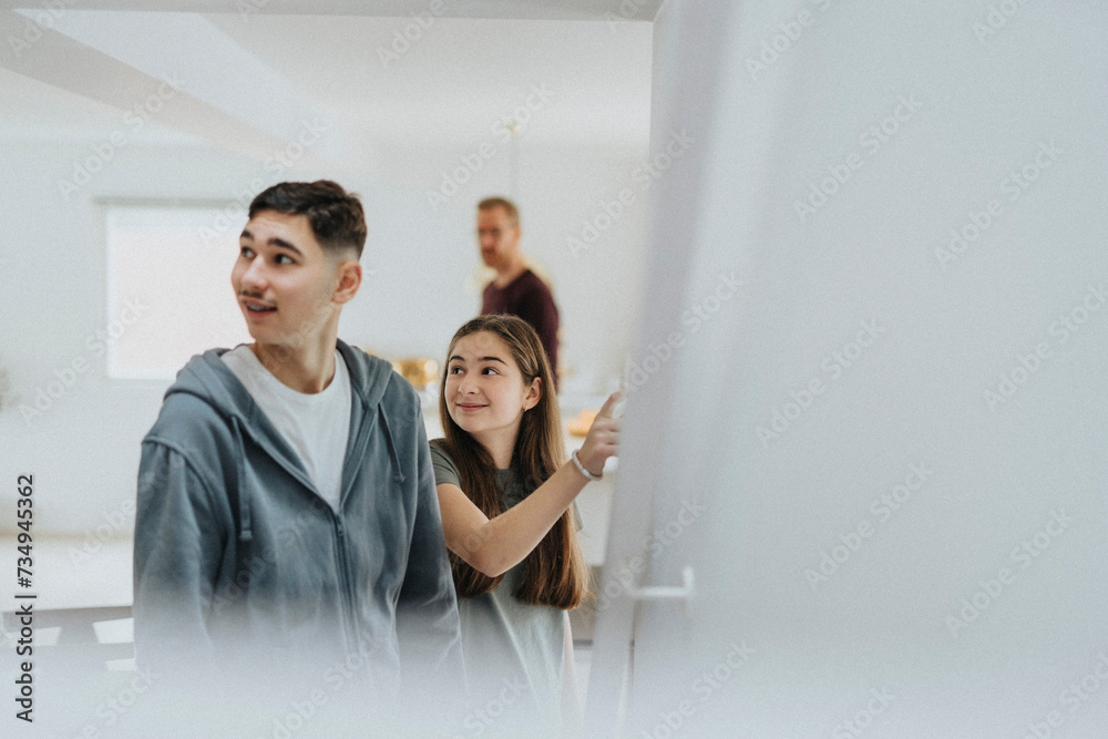 Smiling girl and boy looking away while standing at modern home Smiling girl and boy looking away while standing at modern home