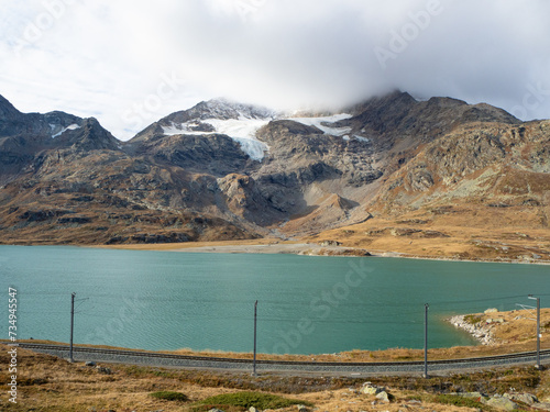 Bernina, Switzerland - October 15th 2023: Piz Cambrena with glacier from Bernina with lake and railway line photo