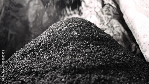 Biochar crumbles in a heap, coal particles falling, Pyrolysis, Decarbonization.
