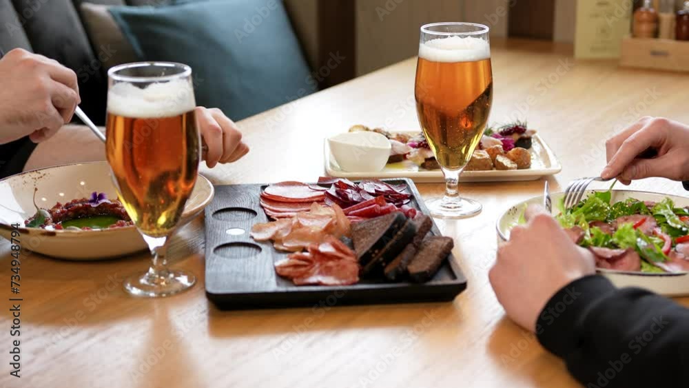 Two unrecognisable young men eating lunch in a beer restaurant. Two friends meet for lunch Two unrecognisable young men eating lunch in a beer restaurant. Two friends meet for lunch