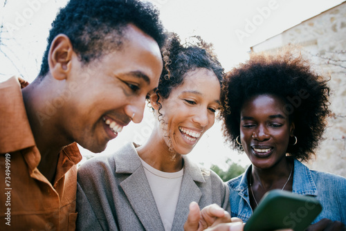 Happy woman sharing smart phone with friends at backyard photo