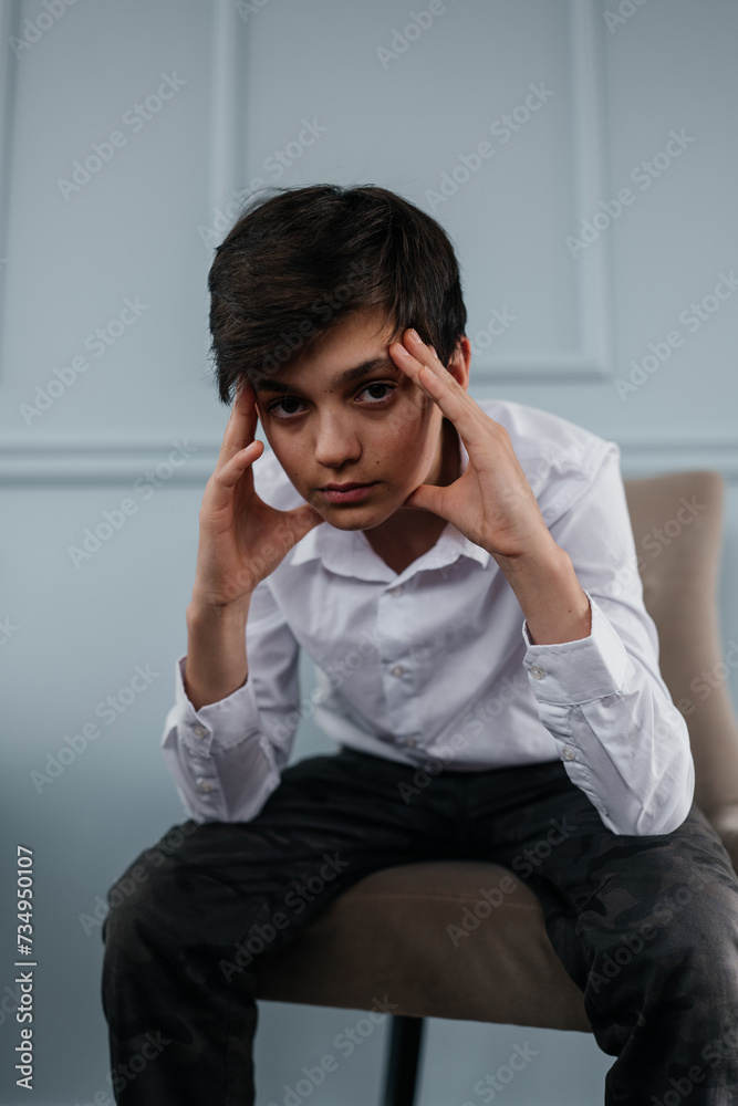 portrait of a handsome teenager sitting on the chair indoors portrait of a handsome teenager sitting on the chair indoors