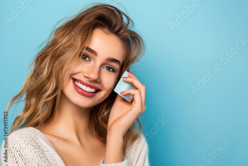 smiling beautiful girl holding a bank card, shopping concept, on a blue background