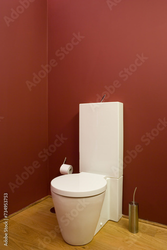 casa de banho, sanita moderna em parede em vermelho com chão em madeira  photo