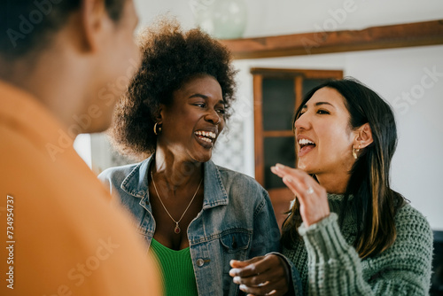 Happy woman talking with friends at party in kitchen photo