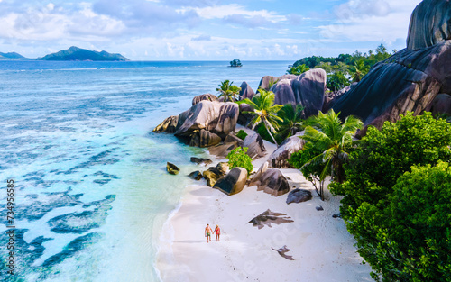 Anse Source d'Argent beach, La Digue Island, Seyshelles, Drone aerial view of La Digue Seychelles bird eye view.of tropical Island, couple men and woman walking at the beach during sunset at a luxury photo