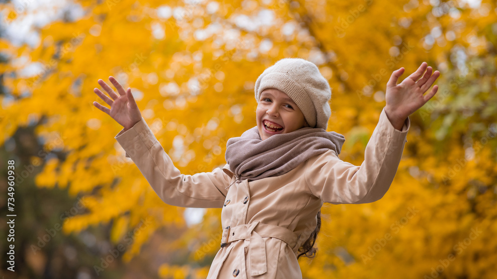 Happy caucasian girl in a beige coat and beret walks in the park in autumn. Happy caucasian girl in a beige coat and beret walks in the park in autumn.