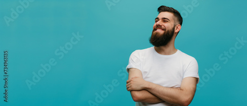 Bonito jovem barbudo em camiseta branca sobre fundo azul