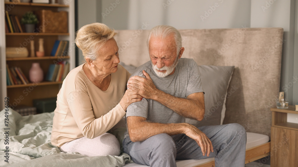 Elderly woman comforting her ill husband in bedroom Elderly woman comforting her ill husband in bedroom