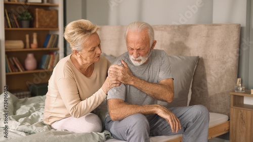 Elderly woman comforting her ill husband in bedroom