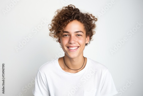 Cheerful young man with curly hair smiling brightly, portrait of happiness and youth