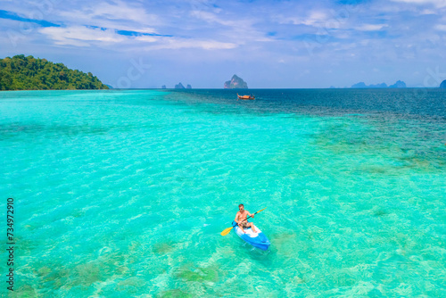 Young man in a kayak at the bleu turqouse colored ocean of Koh Kradan a tropical island with a coral reef in the ocean  Koh Kradan Trang Thailand