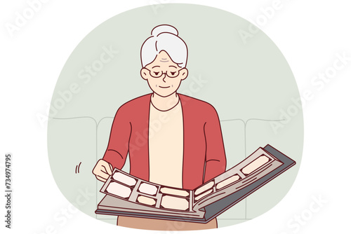 Elderly woman flips through family photo album, remembering student years or fun trips with friends. Grey-haired grandmother sitting alone on couch looking at photos from past. Flat vector design