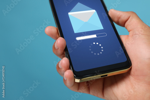 Wallpaper Mural Got new message. Man holding smartphone on light blue background, closeup Torontodigital.ca