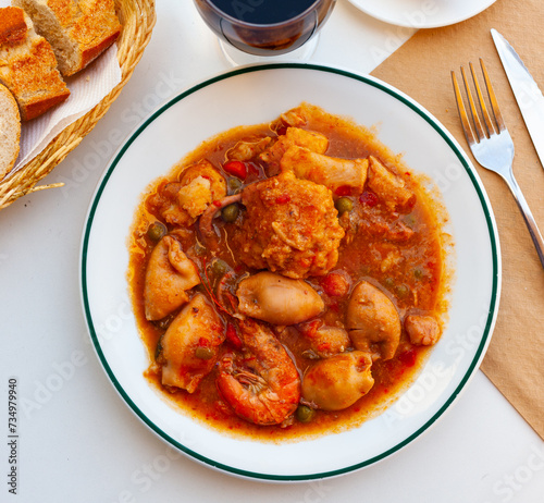 Photos Close up of traditional spanish zarzuela on white plate on white tablecloth