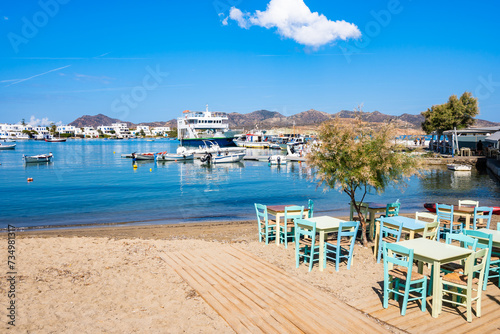 Greek tavern restaurant with tables on beach in Pollomia port, Milos island, Cyclades, Greece photo