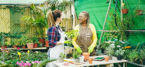 Canvas Print Multiracial women working together inside nursery greenhouse - Green market conc