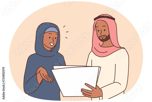 Smiling Arabic businesspeople discuss paperwork
