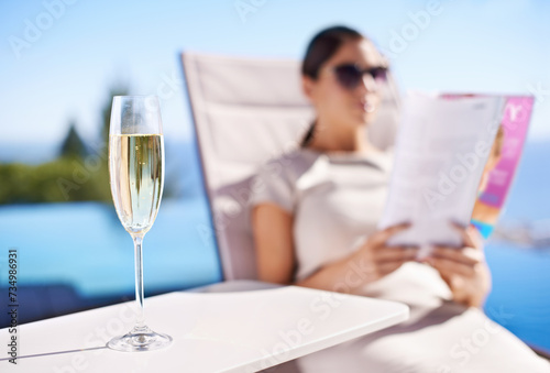 Relax, pool and woman with champagne, magazine and reading in lounge chair on business trip. Travel, hospitality and businesswoman on deck with wine, book and sunshine holiday at luxury villa hotel
