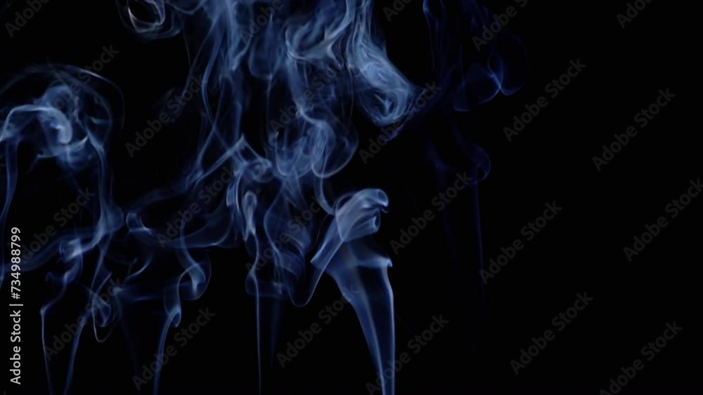 Thin Curls of Blue Smoke Rise Up, Fill Empty Space on a Black Background. Incense sticks. Abstract shapes. Texture. Beautiful clouds of smoke swirl. Floating fog, flowing smoke. Blurred motion. Light. Thin Curls of Blue Smoke Rise Up, Fill Empty Space on a Black Background. Incense sticks. Abstract shapes. Texture. Beautiful clouds of smoke swirl. Floating fog, flowing smoke. Blurred motion. Light.