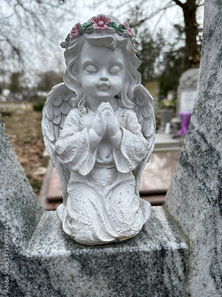 Angel figurine on a tombstone in the public cemetery Angel figurine on a tombstone in the public cemetery