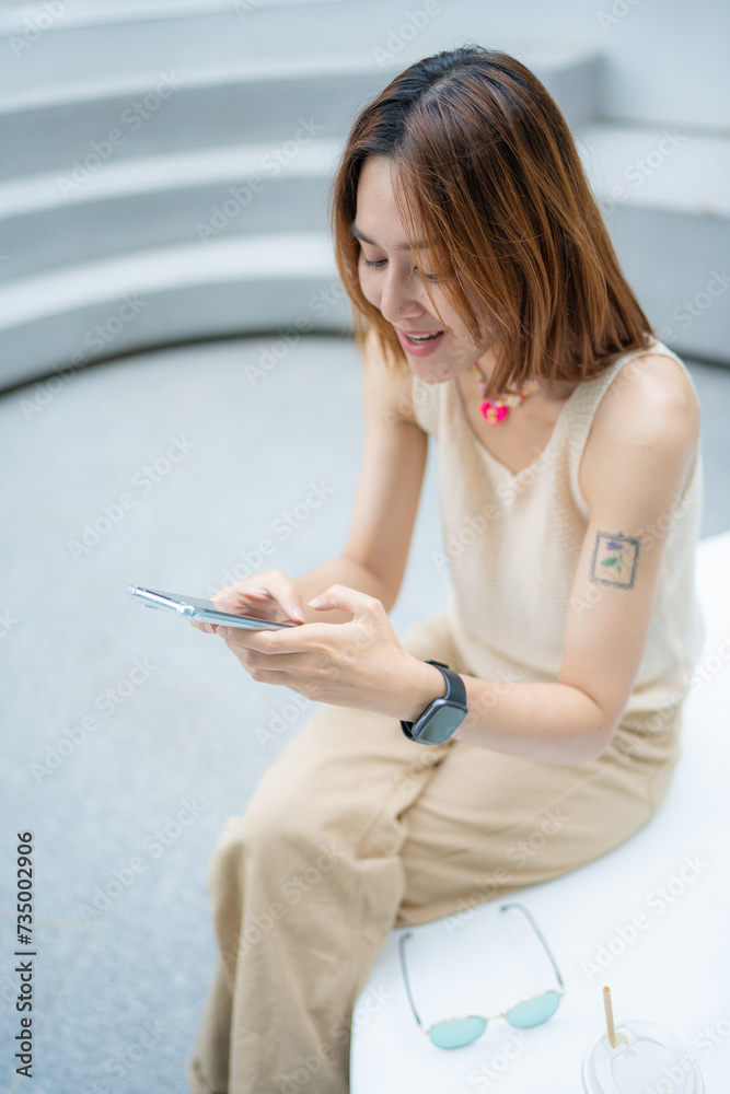 Fototapeta premium Business asian woman sitting outdoor office cafe use smartphone