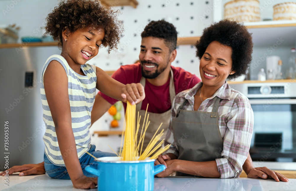 Happy african american family preparing healthy food in kitchen, having fun together on weekend Happy african american family preparing healthy food in kitchen, having fun together on weekend