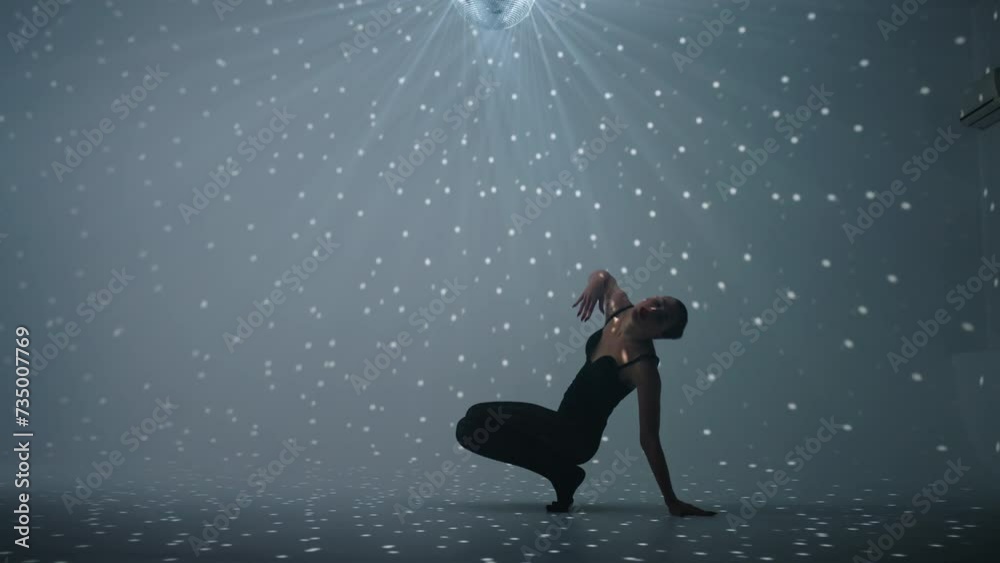 Graceful Woman Dancer In Black Suit Dancing In White Studio With Art Light, Full-Length Shot Graceful Woman Dancer In Black Suit Dancing In White Studio With Art Light, Full-Length Shot