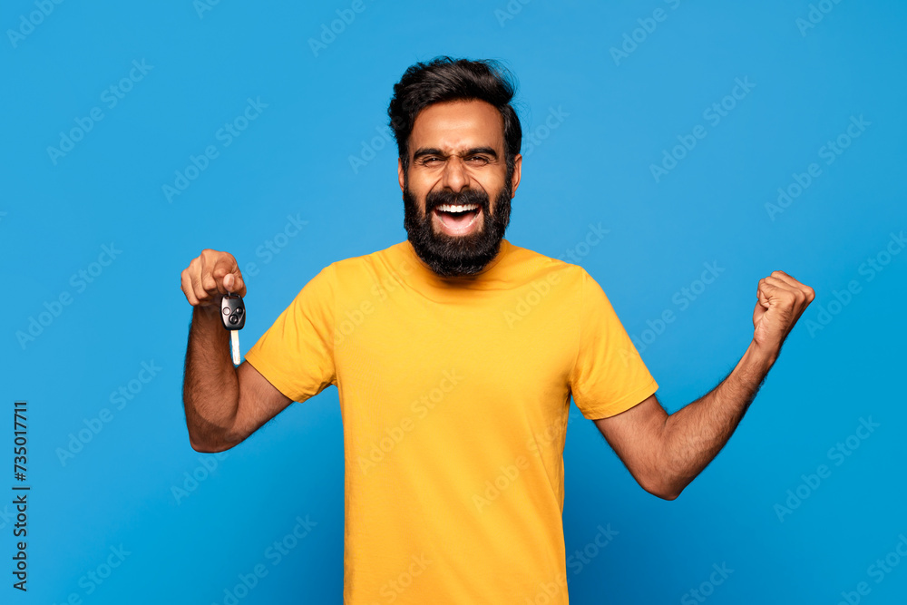 Excited indian bearded man with car keys celebrating Excited indian bearded man with car keys celebrating