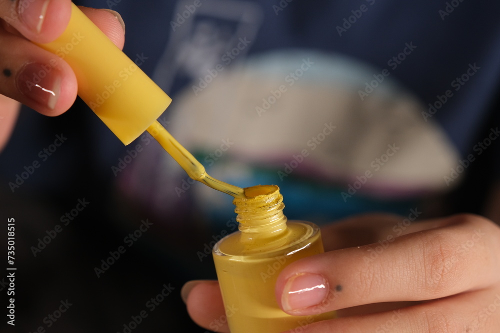 Naklejka premium woman opens nail polish cap