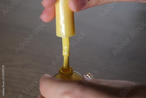 woman opens nail polish cap