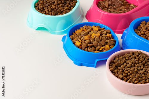 Plastic pet bowls with food isolated on white background