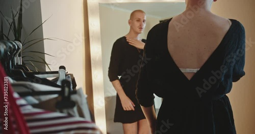 Trans in black dress enjoying his feminine image in mirror, proud homosexual photo