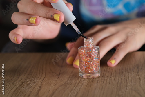 woman opens nail polish cap